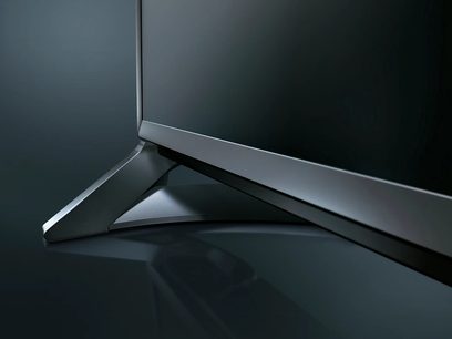 Panasonic TX-65CX800 flat screen TV, side view, metallic gray frame, silver V-shaped stand