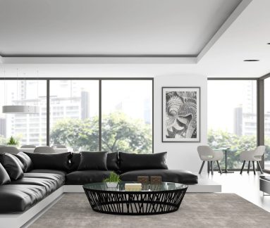 Schwarzer ovaler Couchtisch mit Glasplatte in einem modernen Wohnzimmer mit schwarzem Ecksofa