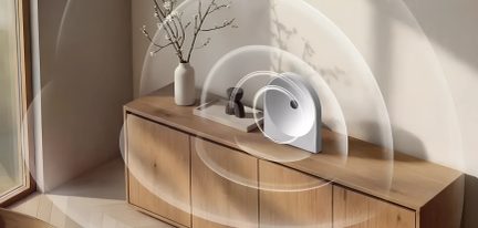 Altoparlante di design bianco su una credenza in legno chiaro con onde sonore illustrate in un interno minimalista