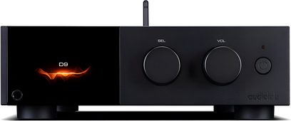Audiolab D9 svart metallisk DAC-ljudomvandlare, sedd framifrån, rektangulärt hölje på fötter med blank skärm till vänster som visar orange mönster och texten D9, två stora roterande rattar för val och volym i mitten, strömknapp och LED till höger, smal vertikal antenn i bakgrunden