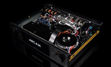Black metal hi-fi amplifier, open cover, three-quarter view, toroidal transformer, boards, volume knob, ARCAM display