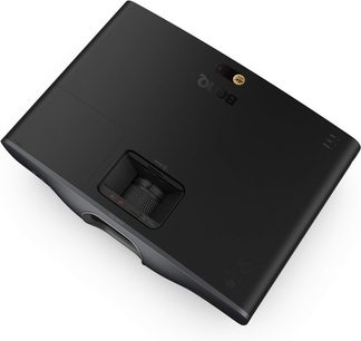 Proyector BenQ W2720i negro, vista en ángulo superior, superficie lisa, rueda de ajuste integrada, lente visible en la parte frontal