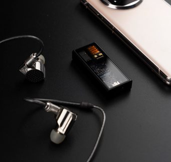 Metalliske ørepropper, svart lydadapter med synlige komponenter, hvit smarttelefon med metallkanter