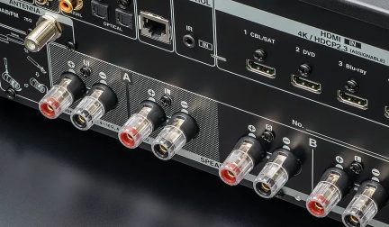 Conectores de áudio e vídeo na parte traseira de um aparelho eletrônico preto, incluindo entradas HDMI, ópticas e antena FM