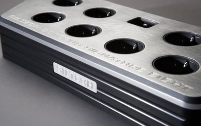 Ciabatta multipresa Siltech Octopus Signature Eight Cu in alluminio spazzolato argento, corpo nero, otto prese rotonde, vista a tre quarti