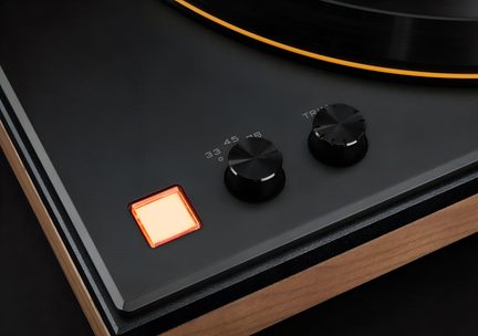 Platine vinyle noire vue de près, boutons de réglage noirs, interrupteur lumineux orange et finition bois