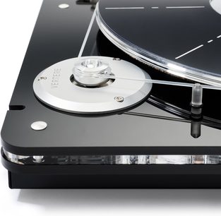 Nærbillede i fugleperspektiv af Vertere Acoustics Pack DGX Mystic II sort hi-fi pladespiller, sort højglans akrylchassis med sort pladetallerken, cirkulær sølvfarvet aluminiumsmotorplade med indgravet Vertere-logo og gennemsigtig drivrem