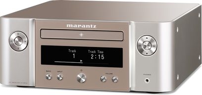 Marantz MCR-612 sølv høyttalersystem med CD-spiller, LCD-skjerm som viser "Track 1 2:15", knapper og kontakter på frontpanelet