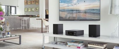 Denon RCD-N10 hvidt lydsystem med højttalere, TV-møbel, havbræt, i et moderne og lyst interiør