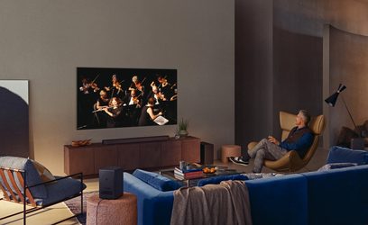 Televizor Samsung QE85QN900A zobrazující orchestr hudebníků hrajících na strunné nástroje v moderním obývacím pokoji