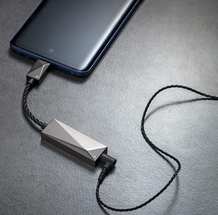 Bærbar Astell&Kern PEE51 sort mat lydkonverter, sort flettet kabel, forsølvede stik, på grå overflade