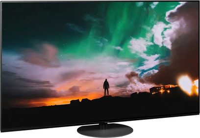 Panasonic TX-65JZ980E-fladskærm, der viser en menneskelig silhuet på en klippe foran en flammende grøn og orange skyet himmel