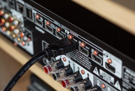 Siyah bir elektronik cihazın arka tarafındaki RCA ses bağlantı noktaları, ön taraftan yakın çekim görüntü