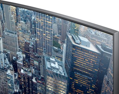 Samsung UE65JU7500-skærm, der viser et luftfoto af oplyste skyskrabere i en by om natten