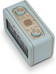 Radio til bordet Roberts Revival Rest i himmelblåt kunstlæder med gyldne kanter, mørkt digitalt frontdisplay med urvisning, øverste beige panel med to store drejeknapper og en central højttalergitter, set i trekvarts fugleperspektiv