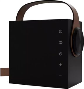 Enceinte bluetooth portátil Morel Biggie preta, caixa cúbica em plástico preto cósmico com alça arqueada marrom no topo e grande botão lateral no lado direito, vista de três quartos à frente