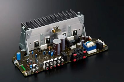 Elektronikkort med silverfärgad kylfläns, cylindriska kondensatorer, RCA-kontakter, olika komponenter, perspektivvy