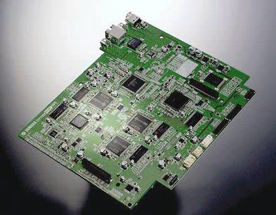 Zielona płytka drukowana z licznymi czarnymi i srebrnymi komponentami elektronicznymi, widok z góry z bliska