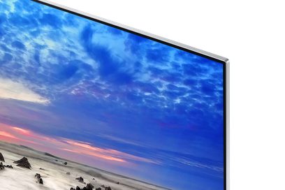 Samsung UE55TU7005-TV som visar en molnig blå himmel med en rosa och orange solnedgång, sedd framifrån
