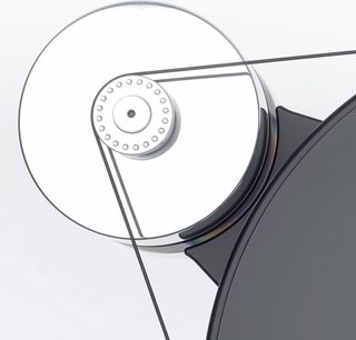 Nærbilde sett ovenfra av Transrotor Dark Star Silver Shadow RB330 hi-fi platespiller, sirkulært sølvfarget platetallerken i polert metall med perforert sentral trinse og en tynn svart rem som forbinder en delvis synlig matt svart platetallerken