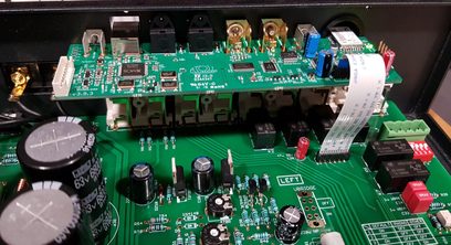 Green printed circuit board with various electronic components including capacitors and resistors, close-up top view