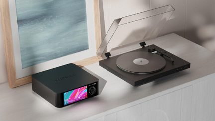 Компактний чорний мережевий підсилювач Eversolo з кольоровим екраном, розташований поруч із вініловим програвачем із відкритою кришкою