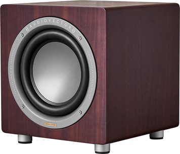 Subwoofer AudioVector QR Sub SE in noce, vista tre quarti anteriore, cabinet cubico in legno di noce scuro con venature a vista, altoparlante circolare con membrana grigia circondata da un anello in alluminio, poggiato su quattro piedini cilindrici metallici