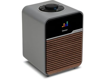Radio Ruark Audio R1S gris, carcasa de plástico mate, frontal negro, pantalla Deezer, rejilla de listones de madera, vista en tres cuartos