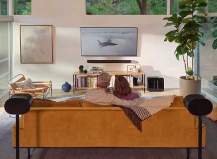 Sistema home cinema Sonos con soundbar a parete, subwoofer ed effetti posteriori in un soggiorno moderno