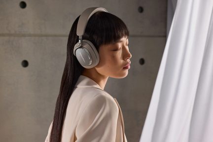 Sive brezžične slušalke Bowers & Wilkins, nošene v profilu, s širokim naglavnim obročem in okoliušesnimi ušesnimi školjkami