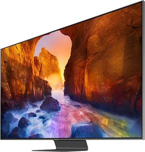 Televizor Samsung QE75Q90R zobrazující barevný obraz skalního kaňonu s přírodním obloukem při západu slunce