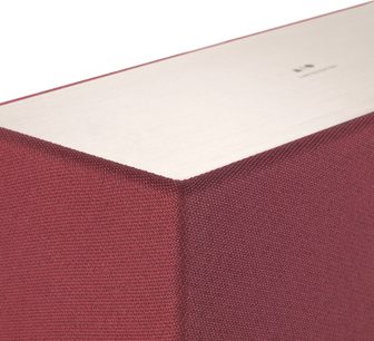 Triangle AIO 3 ocher red speaker, close-up view of an upper corner showing the red textile finish and white frame