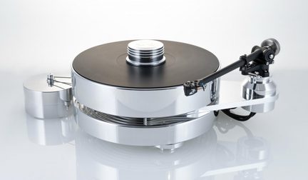 Prata de vinil em metal polido vista de três quartos frontal, prato circular preto fosco com um grampeador metálico estriado acima, braço de leitura preto montado em suporte isolado à direita, bloco motor cilíndrico combinado conectado por correia à esquerda