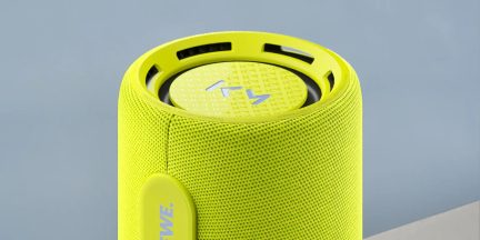 Prenosni Bluetooth zvočnik JBL v fluorescenčno rumeni barvi, pogled od zgoraj, z mrežasto prevleko in vidnim pasivnim radiatorjem