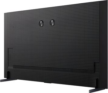 Televisor de alta definición TCL 98C8K negro con plástico texturizado en cuadrícula, vista trasera en ligera diagonal, con dos discos metálicos centrales, una ranura de ventilación larga en la parte inferior y dos patas metálicas planas en los extremos