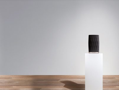 Trådløs, tilsluttet Bowers & Wilkins Formation Flex sort højttaler, set forfra, placeret på en hvid træsokkel