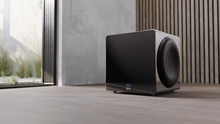 Caisson de basses SVS noir laqué, design cube avec haut-parleur latéral, vue trois quarts en intérieur moderne