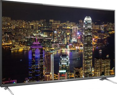 Panasonic TX-55CX700E televiisori eestvaade, mis kuvab öösel valgustatud pilvelõhkujaid ja nende peegeldusi vees