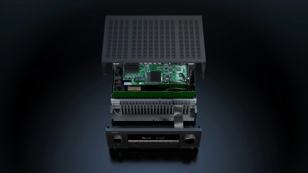 Černý audio zesilovač Denon, pohled zepředu, se sejmutým krytem a viditelnými vnitřními elektronickými součástkami