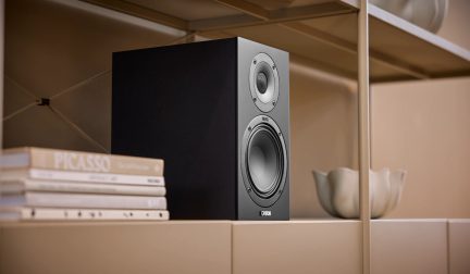 Černý hi-fi regálový reproduktor Canton, dvoupásmová obdélníková ozvučnice umístěná na béžové polici