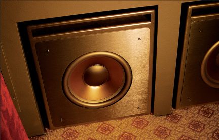 Vista ravvicinata di due altoparlanti incassati, finitura metallica, membrana circolare, pavimento con motivo geometrico