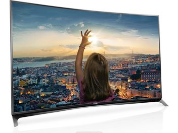 Panasonic TX-65CR850 TV displaying a city at sunset, a woman from behind raising her arm towards the sky