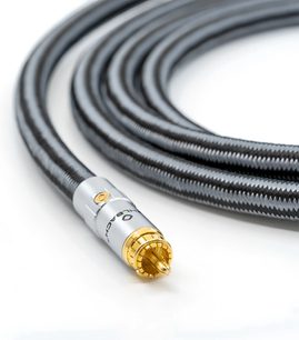 Widok z lekkiego nachylenia na kabel do subwoofera Oehlbach Sub Xtreme w czarnym, nylonowym oplocie, z prostą, srebrną końcówką RCA i pozłacanymi stykami
