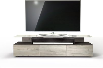 Nízký TV stolek ze světlého dřeva se třemi zásuvkami, na kterém stojí velká černá vypnutá plochá televize