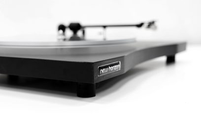 New Horizon 121 sort pladespiller set fra siden, mat sort tonarmsystem og pladespiller, blank sort rektangulær base