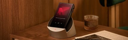 Lettore audio ad alta risoluzione Astell&Kern nero su base bianca, schermo touch rosso e rotella laterale