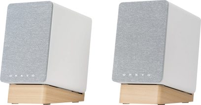 Bezdrátové připojené reproduktory Onkyo GX-10DB bílé, pohled zepředu v perspektivě, bílé skříně, šedé mřížky, podstavce ze světlého dřeva