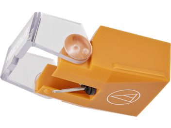 Diamant pro gramofonovou přenosku Audio Technica AT-VMN30xEN s obdélníkovým tělem z žluto-oranžového plastu, pohled v tříčtvrteční perspektivě zleva, viditelným kovovým cantileverovým ramenem a průhledným ochranným krytem