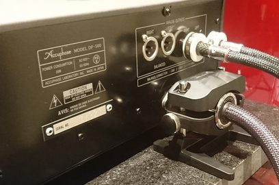 Siyah bir kutuya monte edilmiş gümüş renkli metal XLR ve RCA ses konnektörleri, gri örgülü kablolarla, önden yakın çekim görünüm