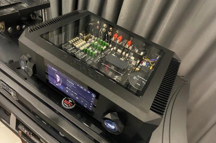 Must audio võimendi läbipaistva ülemise paneeliga, nähtavad elektroonikakomponendid, esiekraanil kuvatakse laul